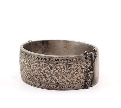 an antique silver bracelet with a chain on the clasp