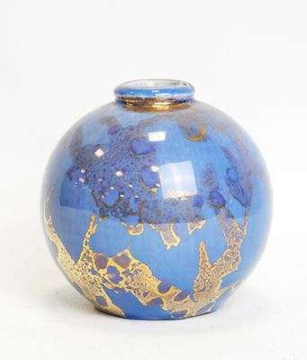 a blue vase with gold designs on it on a white surface