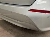 the rear end of a white car with a red tail light
