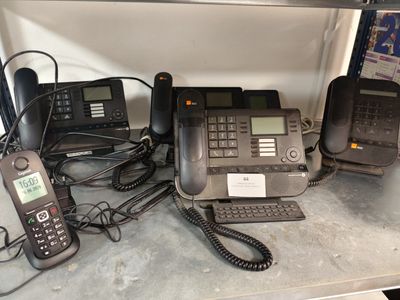 de nombreux téléphones qui prennent la poussière sur une étagère