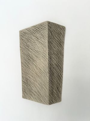 une image représentant une sculpture représentant un bloc de bois posé sur une surface blanche