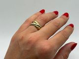 the woman ' s hand is holding a gold ring on her left hand