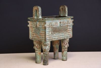 un petit objet métallique posé sur une table, sur fond noir