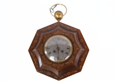 a wooden clock hanging from the wall on a white background