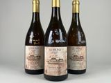 trois bouteilles de vin sont alignées sur une table
