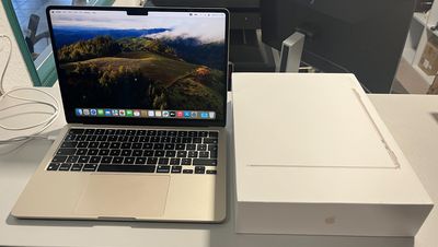un ordinateur portable posé sur un bureau, à côté d'une boîte