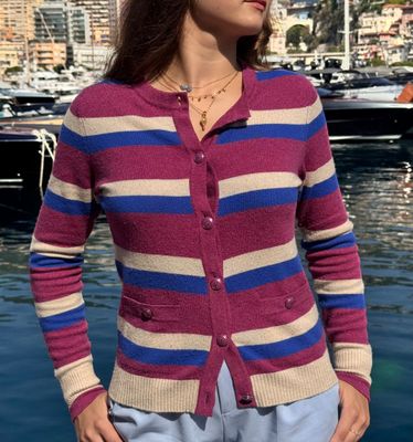 une femme debout devant un plan d'eau, avec des bateaux en arrière-plan