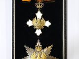 une photo représentant une médaille et une croix dans un écrin noir