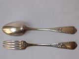two silver spoons and a fork on a table