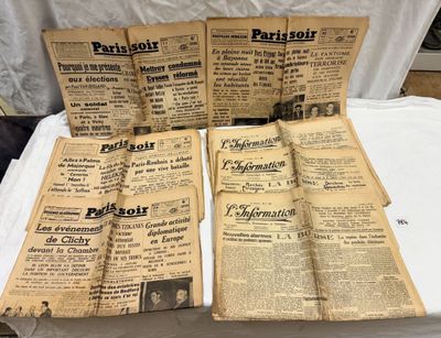 plusieurs vieux journaux posés sur une table recouverte d'une nappe blanche