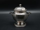 an antique silver teapot with a lid on a black background