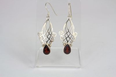 a pair of silver and garnetite earrings on a clear display case