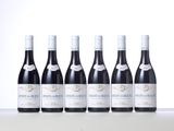 six bottles of wine are lined up on a table