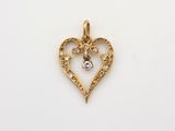 un pendentif en forme de cœur en or, orné d'un diamant au centre
