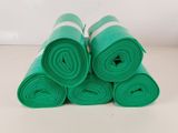 des rouleaux de tissu vert enroulés sur une surface blanche