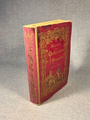 an old book sitting on top of a table on a gray surface