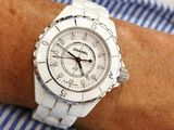 someone is wearing a white watch on their wrist on a blue and white striped shirt