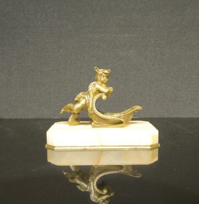 figurine plaquée or représentant un garçon dans un bateau