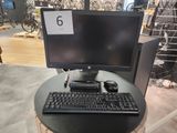 un ordinateur posé sur une table, avec un clavier et une souris