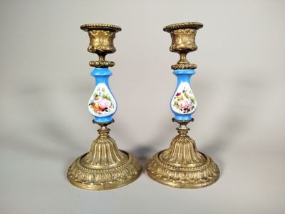 deux bougeoirs en or ornés de motifs bleus et blancs
