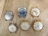 several different types of watches are displayed on a wooden surface