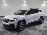 un 4x4 blanc garé sur un sol en damier dans un garage