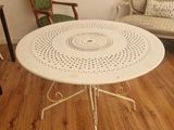 une table et des chaises blanches dans une pièce au sol en parquet