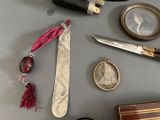a table with various items on it including a knife, a pocket watch, a book, and a pair of scissors