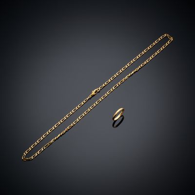 un collier en or et une bague sur fond noir