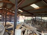 a large pile of wood in a building with a roof