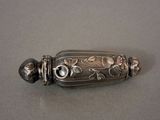 a silver object with flowers on it sitting on a table