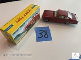 une petite voiture rouge à côté d'une boîte sur laquelle figure un numéro