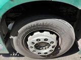 a close up of a flat tire on a green truck