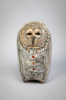 une figurine de chouette posée sur une surface blanche
