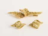 trois broches en feuille d'or sur un fond blanc