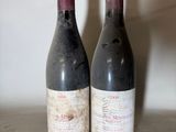 two bottles of wine sitting on top of a table next to each other