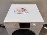a white washing machine sitting on top of a wooden pallet