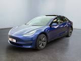 une Tesla Model 3 bleue garée dans une pièce vide