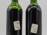 two bottles of wine are sitting next to each other on a table
