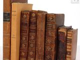 plusieurs vieux livres sont empilés sur une surface blanche