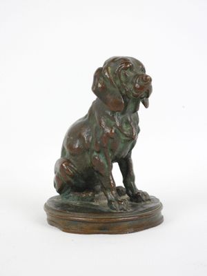 statue en bronze représentant un chien assis sur un socle en bois