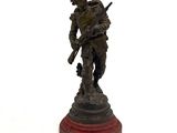 une statue en bronze représentant un soldat tenant un fusil