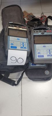 deux appareils électroniques posés sur un sac posé par terre