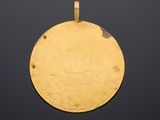 a close up of a gold medal with a medallion on it