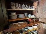many dishes and glasses on the shelves in this old kitchen