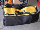 a yellow and black duffel bag sitting on the floor