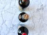 three bottles of wine are lined up on a marble surface