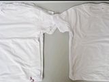 two white t - shirts are sitting on a table next to each other