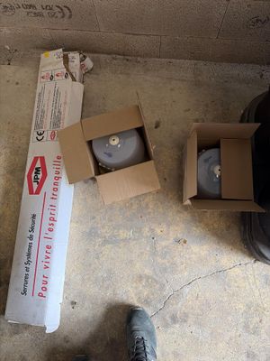 a person standing next to a box and a pair of shoes on the floor