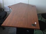 une table en bois avec une chaise noire dans un coin de la pièce